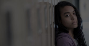 girl who is sad leaning against a locker