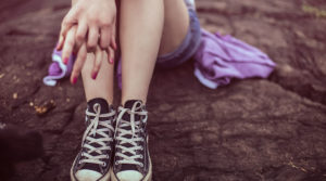 woman holding her hands together on her knees